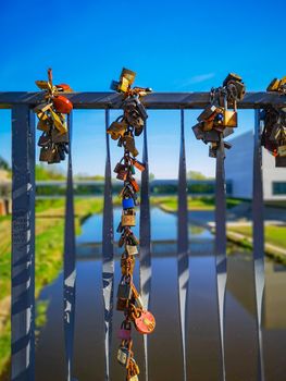 Colorful padlocks hanged on Tumski Bridge in Poznan at sunny day