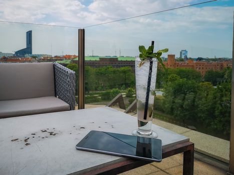 Work on terrace with tablet drinking lemonade with colorful look from viewpoint