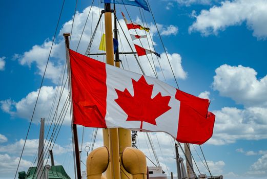 Maple Leaf on Huge Canadian Flag flying on an old ship