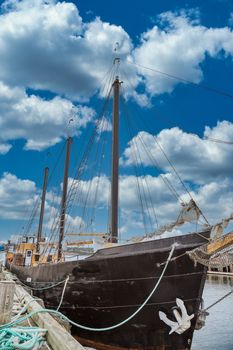 An old wood, three masted schooner with a white traditional anchor