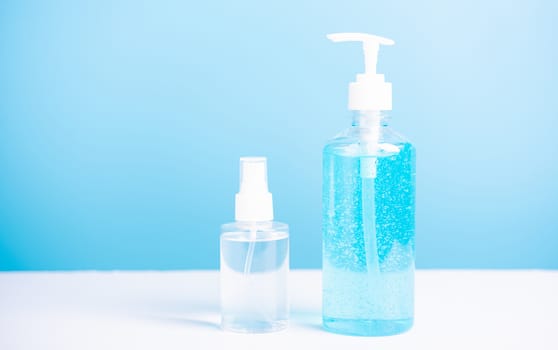 Plastic dispenser sanitizer alcohol gel pump and spray bottle for washing hand hygiene prevention of coronavirus virus studio shot on blue background