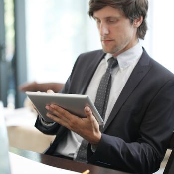 Business man with tablet pc working at office desk