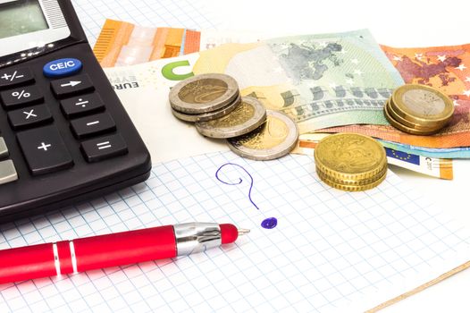 Close up of question mark with calculator and pen. Ball with money, paper on a white background