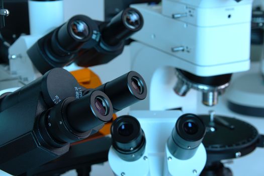 Group of various Microscopes in blue medicine light microbiology research concept