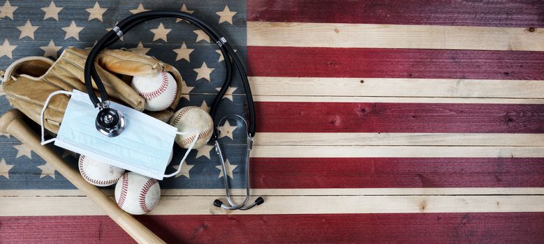 American baseball equipment with surgical protective mask and stethoscope on vintage United States wooden flag background. Coronavirus concept for affect baseball sport season with copy space