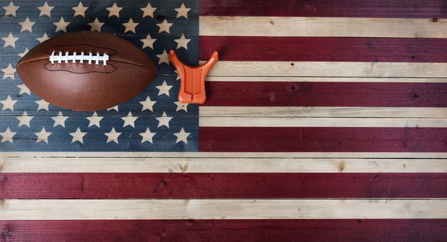 American football with kicking tee on vintage United States wooden flag background. Football sports concept with copy space