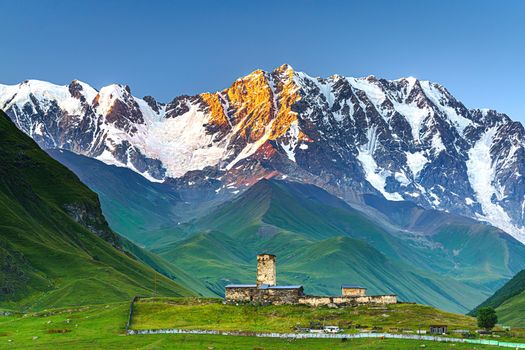 Beautiful landscape with high mountains with illuminated peaks, stones in mountain lake, reflection, blue sky and yellow sunlight in sunrise. Nepal. Amazing scene with Himalayan mountains. Himalayas