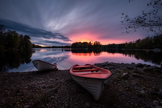 Old wooden rowing boats moored at the pier on the lake Bled. Gorgeous Pillgrimage church and small island in background, Bled, Slovenia, Europe