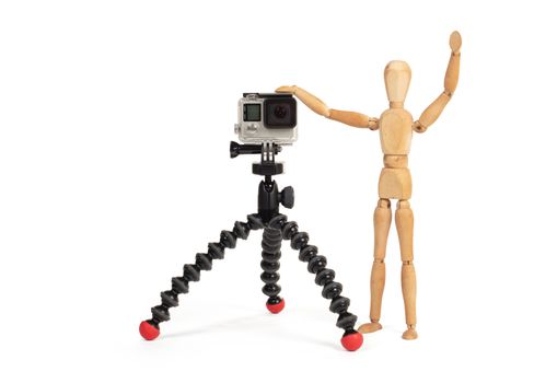 Wooden dummy standing trying to make a video or photo, isolated on white