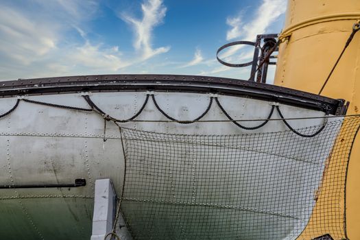 Old fishing net hanging on the white hull of a boat