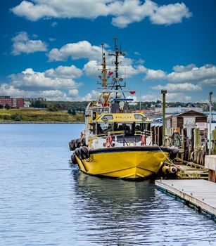 A yellow pilot boat docked at a harbor in Halifax