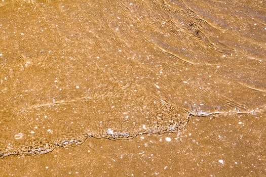 Light reflection on the surface of movement sea on sand beach