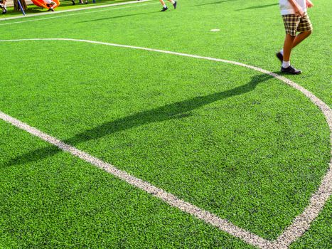 Children play on the artificial turf of the school