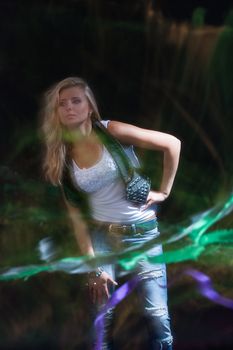 young, blonde girl in jeans clothes on a dark background