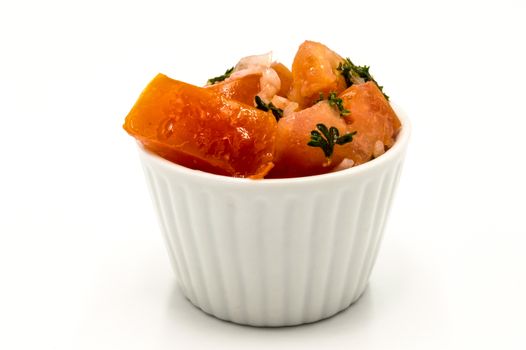 Tomato parsley salad in a white ramekin on a white background