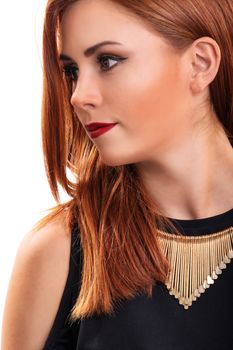 Profile shot of a beautiful, attractive redheaded young woman with clean make up, stylish black blouse and modern necklace, isolated on white background. Fashion and beauty concept.