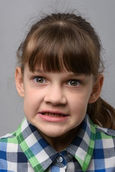 Portrait of an evil ten-year-old girl of European appearance, close-up