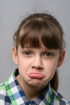 Portrait of a displeased ten-year-old girl of European appearance, close-up