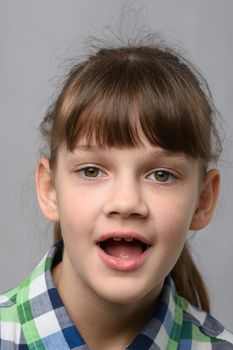 Portrait of a funny ten-year-old girl with wide mouth, European appearance, close-up