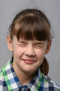 Portrait of a ten-year-old girl who closed her eyes, European appearance, close-up