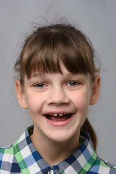 Portrait of a funny ten-year-old girl with a cheerful smile, European appearance, close-up