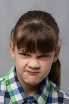 Portrait of a vile ten-year-old girl of European appearance, close-up