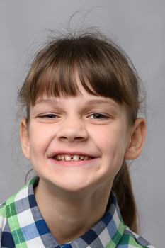 Portrait of a funny smiling ten-year-old girl of European appearance, close-up