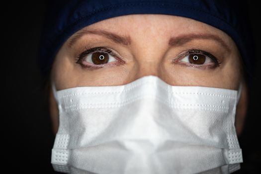 Female Doctor or Nurse Wearing Medical Face Mask on Dark Background.