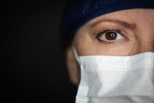 Female Doctor or Nurse Wearing Medical Face Mask on Dark Background.