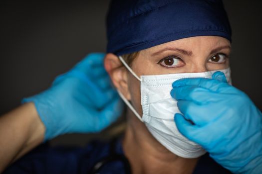 Female Doctor or Nurse Wearing Surgical Gloves Putting On Medical Face Mask.