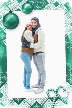 Attractive young couple in warm clothes hugging against christmas frame
