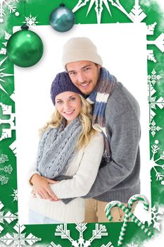 Attractive couple in winter fashion hugging against christmas frame