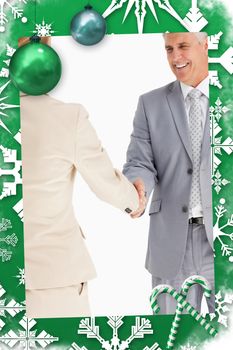 Happy business people shaking hands against christmas frame