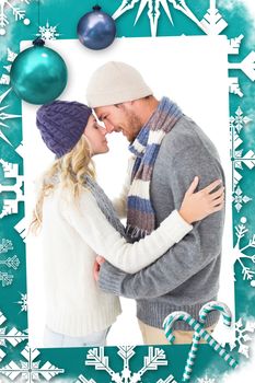 Attractive couple in winter fashion hugging against christmas frame