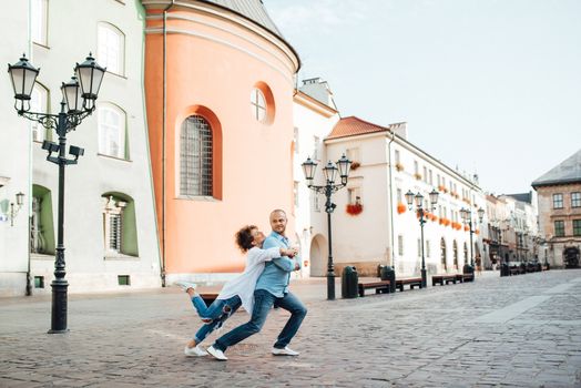 guy and a girl happily walk in the morning on the empty streets of old Europe