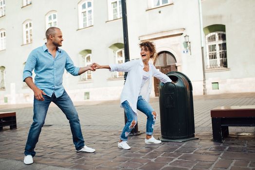 guy and a girl happily walk in the morning on the empty streets of old Europe