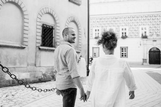 guy and a girl happily walk in the morning on the empty streets of old Europe