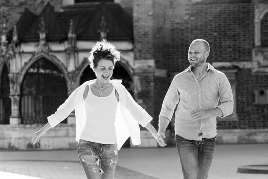 guy and a girl happily walk in the morning on the empty streets of old Europe