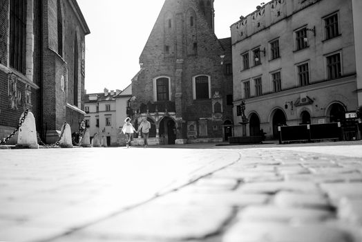 guy and a girl happily walk in the morning on the empty streets of old Europe