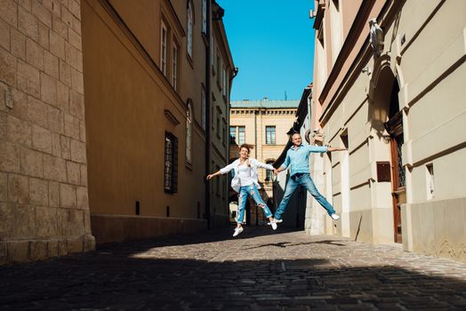 guy and a girl happily walk in the morning on the empty streets of old Europe