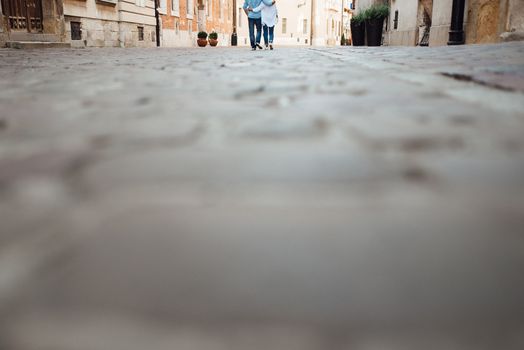 guy and a girl happily walk in the morning on the empty streets of old Europe