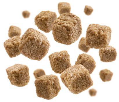Brown cane sugar levitates on a white background.