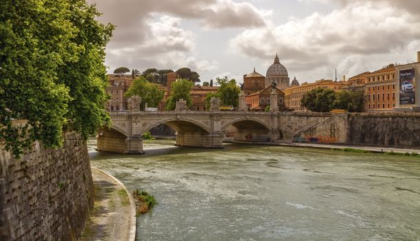 Tiber river, Ponte Sant'Angelo and St. Peter's cathedral by cloudy day, Roma, Italy