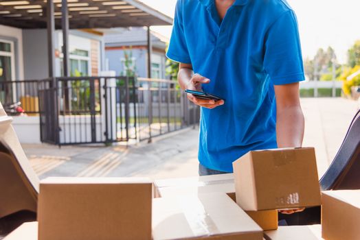 Asian delivery man courier online holding deliveries out boxes and using mobile phone contact the customer he protective face mask service under curfew quarantine pandemic coronavirus COVID-19