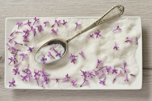 Lilac Sugar In Spoon And Plate On WoodenTable