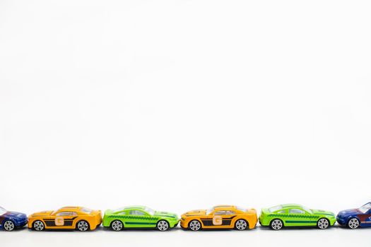 Toy cars of different colors arranged on a white background.
