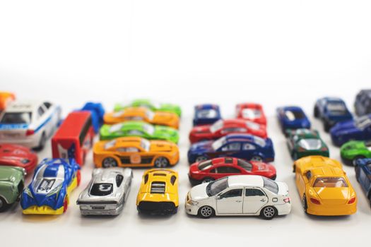 Toy cars of different colors arranged on a white background.