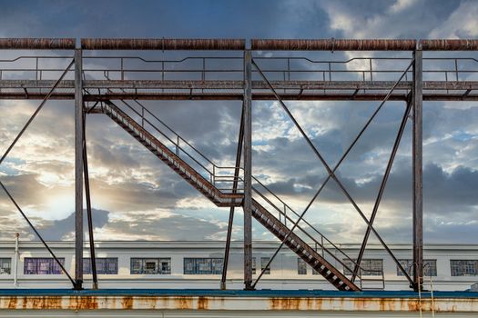 An old rusty staircase from a warehouse to a cat walk