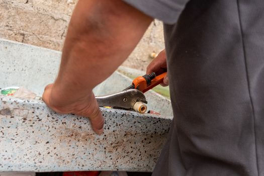 hands of a man fixing a tube of his own house