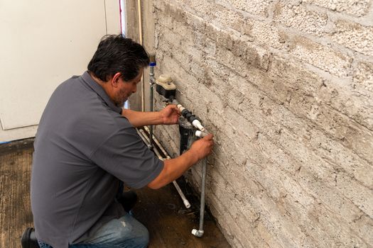 an old man fixing a broken tube of his own house